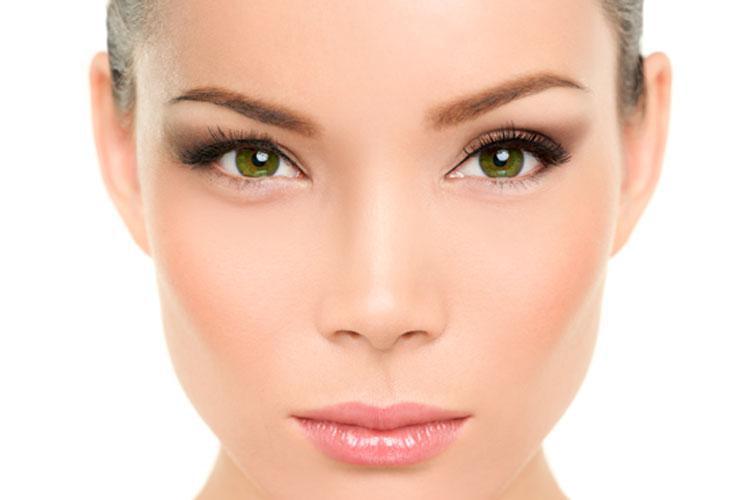 A woman's face with green eyes.